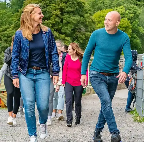 Eine Gruppe junger Erwachsener geht am Erlebnisberg in Altenberg gemeinsam eine Runde spazieren. Sie unterhalten sich und sind alle am lächeln. Entdecken sie eine schöne Zeit am Erlebnisberg in Altenberg.