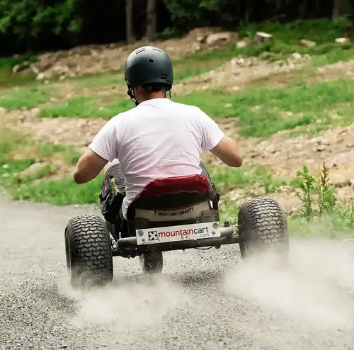vermietung-altenberg-erzgebirge-sachsen-23.webp Ein Mann fährt mit einem Mountainkart einen Berg im Erlebnisberg Altenberg hinunter.