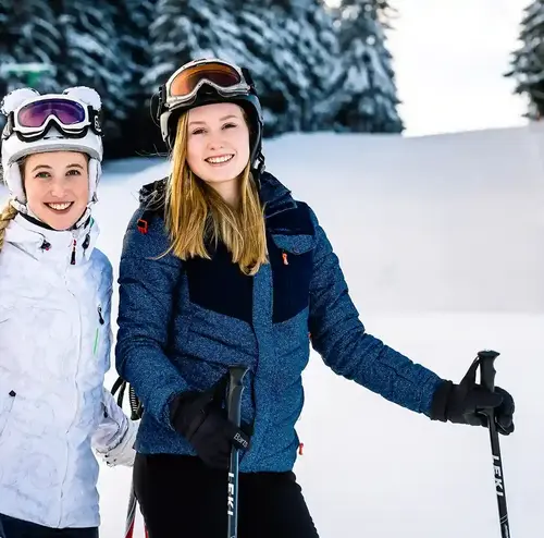 Zwei junge Frauen machen eine Pause von ihrer Skifahrt in Altenberg.