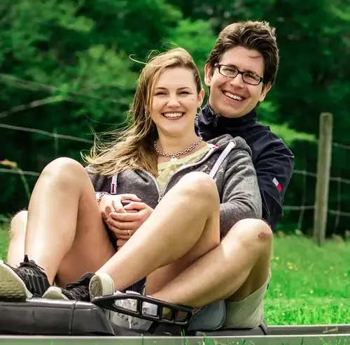 reisegruppen-altenberg-erzgebirge-sachsen-09.webp Zwei junge Menschen fahren mit der Sommerrodelbahn inmitten des Erzgebirges.