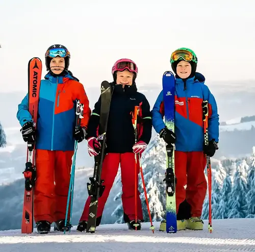 schulklassen-im-winter-altenberg-erzgebirge-sachsen-01.webp Eine Gruppe von Kindern steht vor einer Kulisse mit dem Erzgebirge.