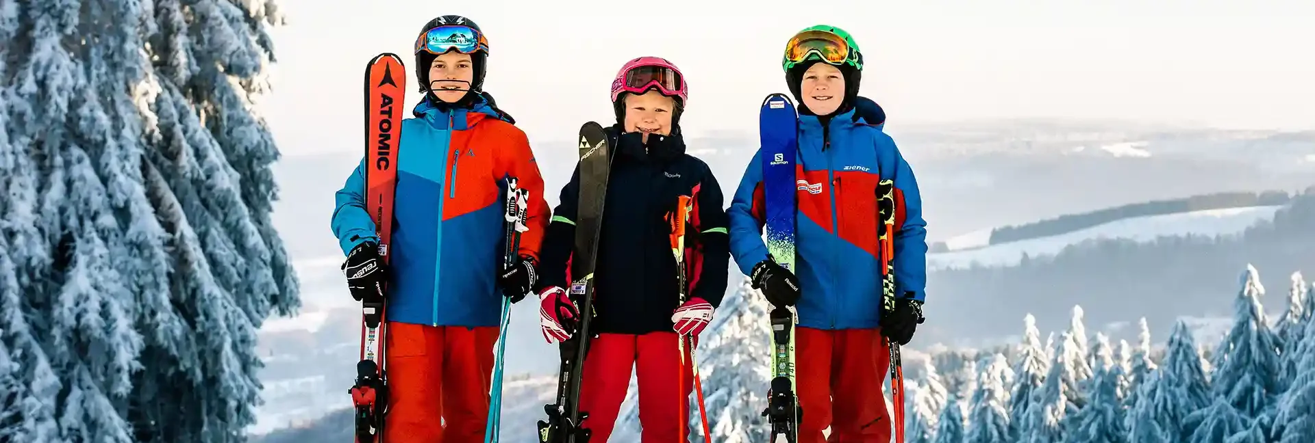 schulklassen-im-winter-altenberg-erzgebirge-sachsen-01.webp Eine Gruppe von Kindern steht vor einer Kulisse mit dem Erzgebirge.