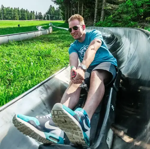 vermietung-altenberg-erzgebirge-sachsen-13.webp Ein Mann fährt mit der Sommerrodelbahn im Outdoor Freizeitpark Altenberg.