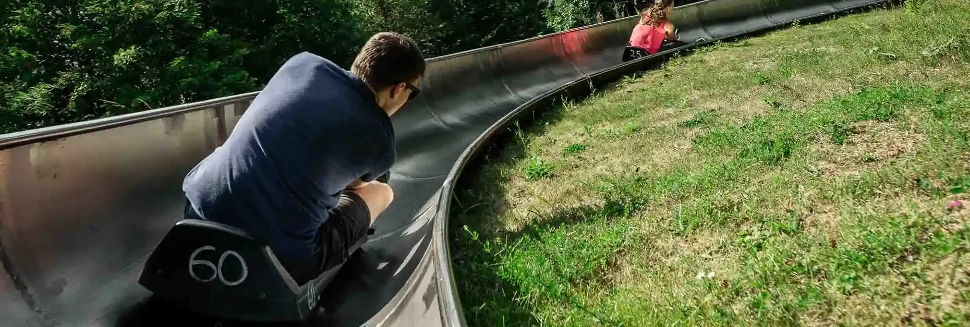 vermietung-feiern-geburtstag-betriebsfeier-erlebnisberg-altenberg-1.webp Zwei Personen rodeln zusammen am Erlebnisberg Altenberg.