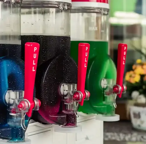 Man sieht verschieden gefärbte Slush-Eismaschinen, diese haben außen Wasserperlen und sehen sehr kühl aus. Entdecken sie verschiedenste kalte Getränke um den Sommer besser zu überstehen in der Rodelklause am Erlebnisberg in Altenberg. 