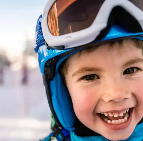 schulklassen-im-winter-altenberg-erzgebirge-sachsen-08.webp Ein kleines Kind freut sich auf seine Skifahrt am Erlebnisberg Altenberg.