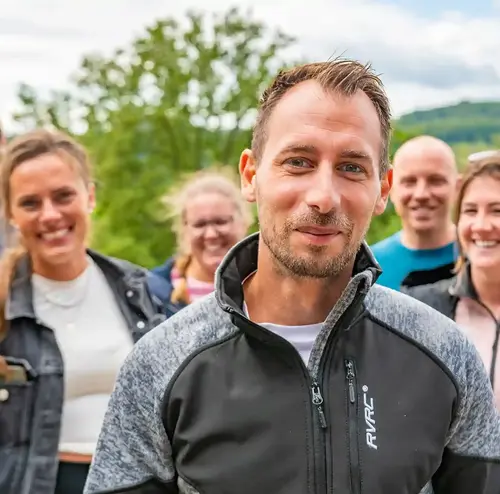 firmenevents-altenberg-erzgebirge-sachsen-27.webp Eine Gruppe eines Firmenevents schauen lachend in die Kamera.