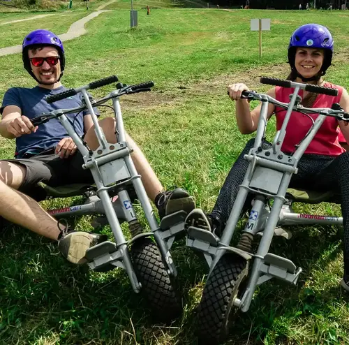 vermietung-altenberg-erzgebirge-sachsen-05.webp Zwei Erwachsene erleben Mountaincart-Abenteuer im Freizeitpark Altenberg