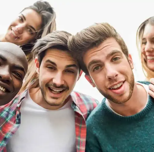 busreisen-altenberg-erzgebirge-sachsen-26.webp Eine Gruppe junger Menschen schauen glücklich in die Kamera während sie am Freizeitpark Altenberg sind.