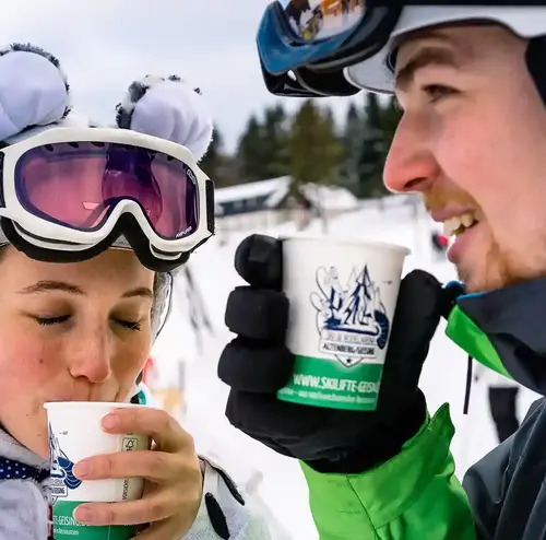 Zwei junge Menschen genießen ein warmes Getränk im kalten Erzgebirge.
