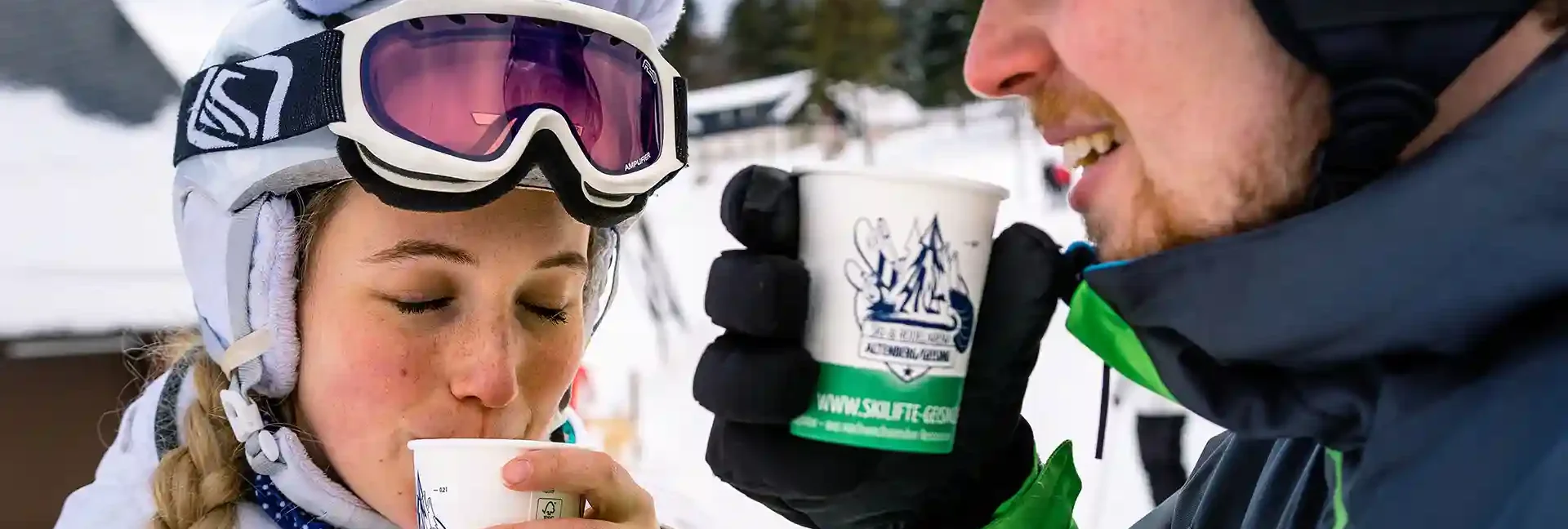 Zwei junge Menschen genießen ein warmes Getränk im kalten Erzgebirge.