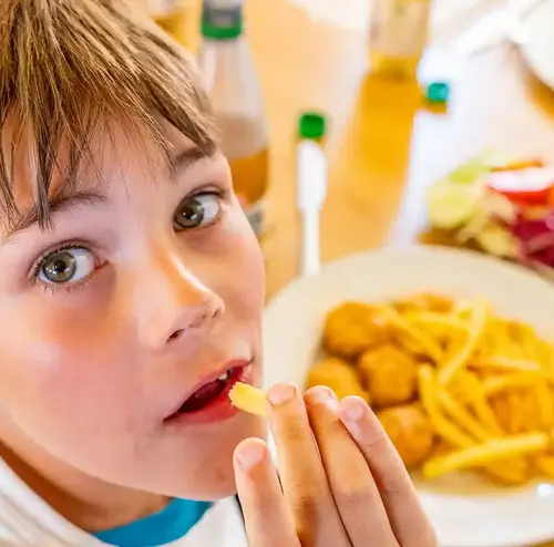 vereine-altenberg-erzgebirge-sachsen-47.webp Ein kleiner Junge ist sein Essen von der Rodelklause im Freizeitpark Altenberg.