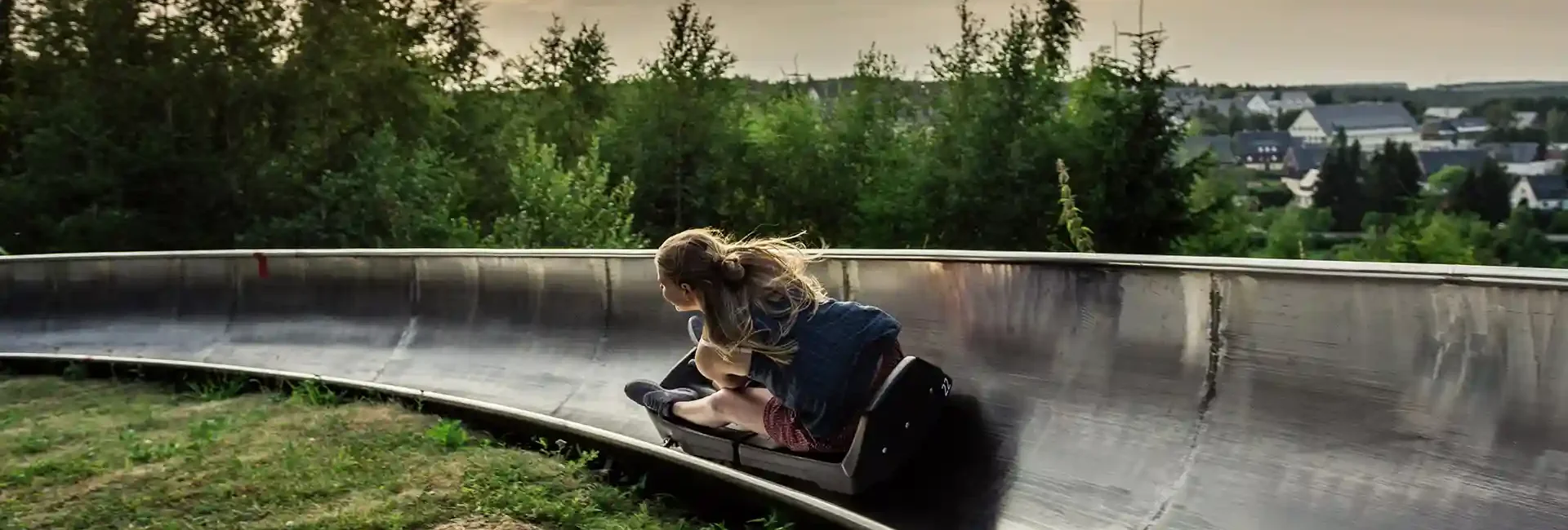 news-mitteilungen-infos-skigebiet-erlebnisberg-altenberg-4.webp Eine Sommerrodelbahn bei Sonnenuntergang.